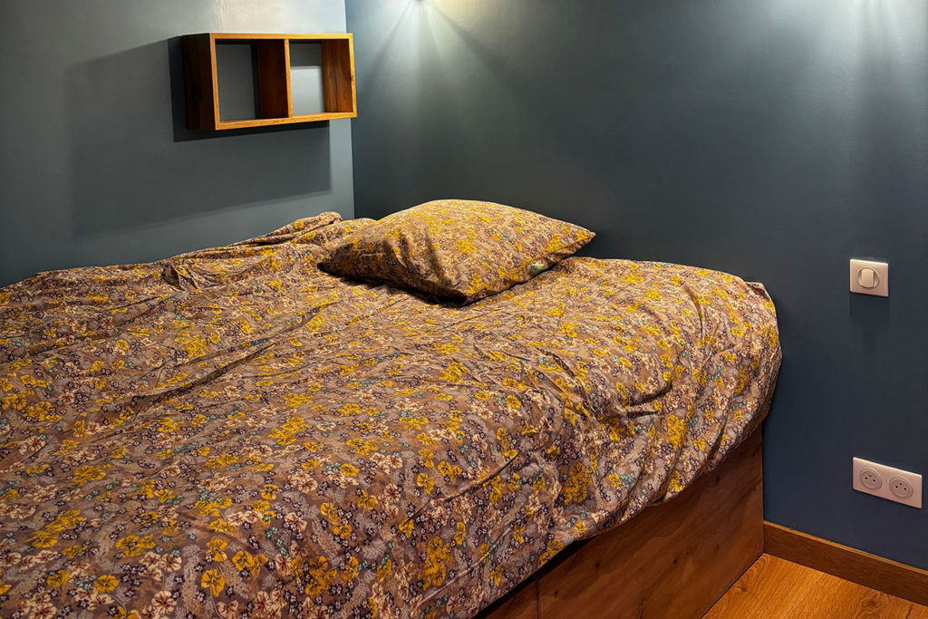 Vue du lit du Studio bleu dans la location étudiante de la Maison du Trichon à Roubaix